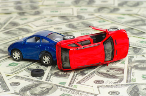 Toy cars in accident on dollar bills representing economic damages in a Miami personal injury claim