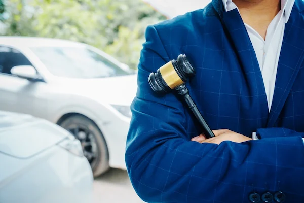 A Fort Lauderdale car accident lawyer stands beside a vehicle.